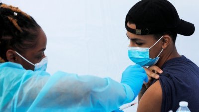 美国一名少年在纽约市的一座校园内，接种辉瑞新冠疫苗。（图取自路透社）
