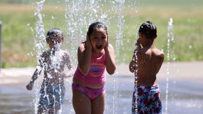 在华盛顿州西雅图市，一群小孩当地时间周六在飞溅公园降温。有关当局警告，西雅图市当地时间周一可能来到前所未闻的摄氏41度新高纪录。(路透社)