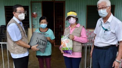 林冠英（左）与周玉清（左3起）及彭文宝，送食物篮给一名峇眼区的居民。（图取自林冠英面子书）