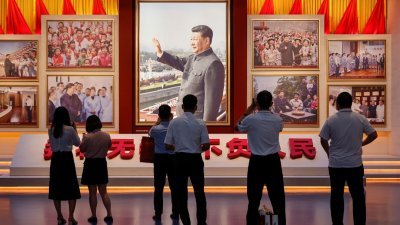 为庆祝中国共产党成立100周年，位于北京的中国国家博物馆举办相关主题展览。参观者在观赏介绍中国国家主席习近平的图片。（图取自路透社）
