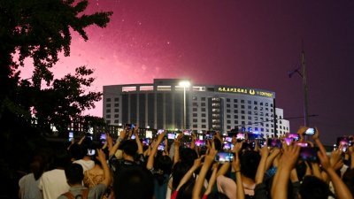 中国共产党将于下月1日迎来建党100周年，北京市鸟巢体育场周一晚上举行大型文艺演出，包括烟花表演等。图为民众当晚于鸟巢体育场的远处观赏烟花。（图取自法新社）