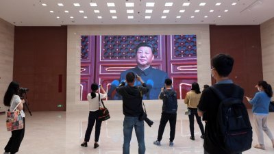 为庆祝中国共产党成立100周年，位于北京的中国国家博物馆举办相关主题展览。这是参观者在观看介绍中国国家主席习近平的影片。（图取自路透社）