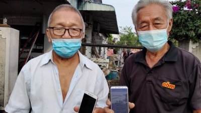 余和平（左）及余金荣展示MySejahtera手机应用程序安排他们前往巴力拉惹接种。