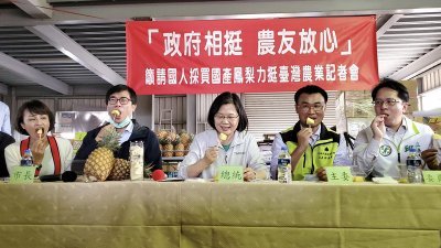 台湾总统蔡英文（中）上周日在高雄市长陈其迈（左2）、农委会主委陈吉仲（右2）等人陪同下，到高雄市大树区黄梨产销班访视农友，众人一同品尝黄梨，力挺农民。 
