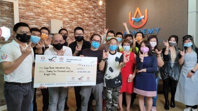 优学院创办人郭义霖（左一）将超过2万令吉的支票转交给公益团体熊猫侠创办人李雁杰（左三）。