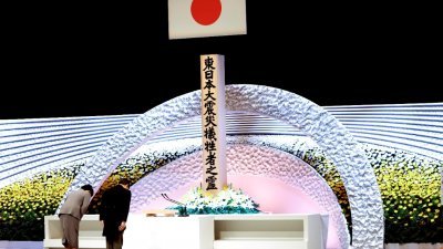 日本天皇德仁伉俪首度出席政府在东京国家大剧院举行的官方追悼仪式。他们向象征大地震中受害者的祭坛鞠躬敬礼致意。
