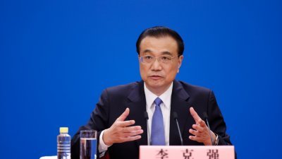 图说：中国总理李克强在北京人民大会堂出席记者会，并回答中外记者提问。为有效防控疫情，记者会采用网络视频形式进行。（中新社）