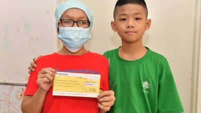黄慧婷（左）接领12万7824令吉80仙的支票后，感谢《东方日报》读者的热心捐献，助她度过难关。（张真甄）