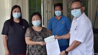 于数个月前痛失老伴的彭秀兰（左2），周二收到由国家灾害管理机构派出的5000令吉新冠肺炎抚恤金。