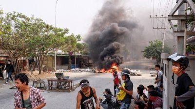 缅甸反政变示威者于周一，在第二大城曼德勒的某处街道上，焚烧杂物制造路障，借此试图阻止防暴警察的推进。（图取自路透社）