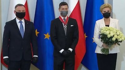 拜仁慕尼黑中锋、波兰国家队队长莱万多夫斯基（中）周一造访了波兰总统府，获波兰总统杜达（左）亲自授予波兰复兴勋章。