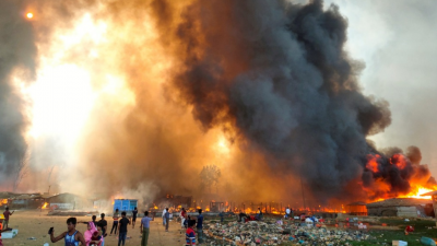 孟加拉国科克斯巴扎尔罗兴亚难民营，于周一发生火灾。图为当天营地中，远处的房子正不断冒出熊熊火光，浓浓的黑烟直窜天际，场景骇人。-路透社- 