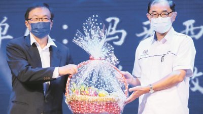 王鸿财（左）赠送水果篮予马汉顺，感谢马汉顺为《华小STEM教育交流会》闭幕。
