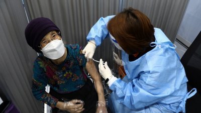 韩国4月起将新冠肺炎疫苗接种计划扩展到75岁以上的长者，这是首尔一名长者周四接种疫苗。（图取自路透社）