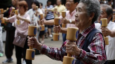 日本政府周四施行《改正高年龄者雇佣安定法》，该国社会将迈入70岁退休时代，而当局目前并没有强制执行这部法律。图为正在做运动的日本年长者。 （图取自路透社档案照）