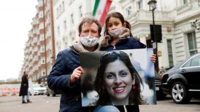 被伊朗囚禁女子拉特克利夫的家人，今年3月手持其照片于驻伦敦的伊朗领事馆门外抗议。（图取自路透社）