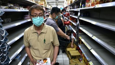 台北民众看新闻得知防疫升级后，立即出门购买可以囤放的食材和民生物质，货架上的快熟面迅即被扫光。（图取自路透社）