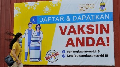 槟州政府在各大街小巷设立大型告示牌，提醒槟民登记及接受疫苗接种。（摄影：蔡开国）