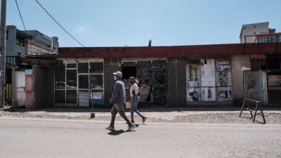 今年10月21日，人们走在埃塞俄比亚首都亚的斯亚贝巴被烧毁的商店前。-法新社-