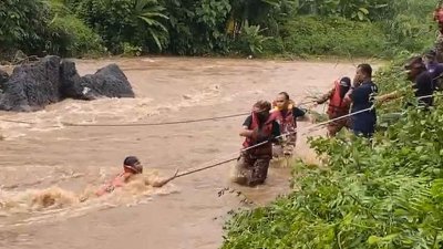 消拯人员在为男童穿上救生衣及套上绳索后，迅速将男童拉回河岸。（视频截图）