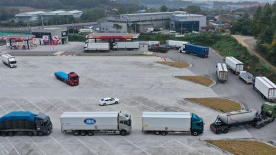许多大型货车在韩国平泽市的服务区排队等候获取尿素。 （图取自路透社）