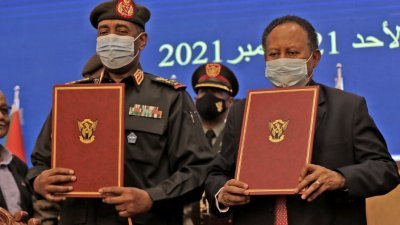 苏丹被罢免的总理哈姆杜克（右）、以及一个月前将他开除的武装部队总司令布尔汉，当地时间周日签署一项突破性的协议，以终止军事管制，而前者重返总理职位。（图取自法新社）