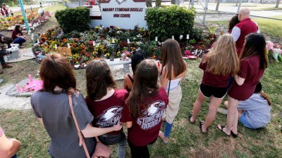 2018年2月14日佛罗里达州帕克兰市玛乔丽·斯通曼·道格拉斯高中发生严重枪案，造成17人死亡。事发后，民众在学校外献花悼念死者。（图取自路透社）