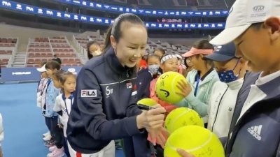根据社交媒体流传的视频，中国网球女子名将彭帅周日在北京出席Fila Kids钻石杯青少年网球挑战赛总决赛，并为孩子于大颗的网球上签名。（图取自路透社/推特账户@QINGQINGPARIS提供）