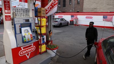图为在美国纽约布鲁克林，一名司机本月11日在加油站替汽车加油的档案照。-路透社-