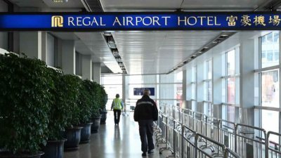 香港政府公布，周六凌晨12时起开始收紧从博茨瓦纳、斯威士兰、莱索托、马拉维、莫桑比克、纳米比亚和津巴布韦到港人士的登机与检疫要求，连同现时已被指明为高风险区的南非，禁止在21天内曾逗留当地的非香港居民入境。图为民众周五前往香港国际机场的富豪机场酒店。（图取自法新社）