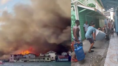 洪都拉斯一个度假岛屿发生大火，烧毁数十栋房屋，浓浓黑烟直扑天际，景象骇人。民众抢救家具和其他财物。（图取自洪都拉斯紧急应变委员会/Reuters TV/路透社）