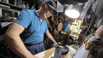 中国上海修琴师冯顺成，在铺子内修理琵琶。（图取自中新网）