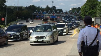 交通警察在爱极乐收费站监督10月15日下午驶入甲州的车流量。
