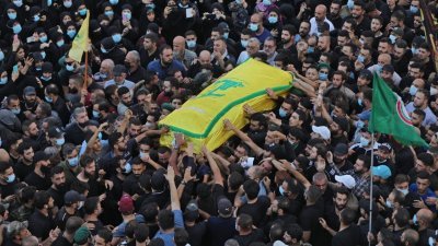 在黎巴嫩首都贝鲁特南部郊区，大批真主党的支持者周五在一名死于街头冲突的成员葬礼上，抬著该成员的棺材。（图取自法新社）