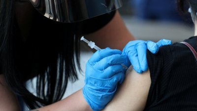 为提升青少年的新冠肺炎疫苗接种率，美国明尼苏达州推出有打针有奖励的计划。图为田纳西州一名学生接种疫苗的档案照。（图取自路透社）