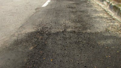 甘密山有一处已修补的路面出现破裂，对道路使用者造成威胁。