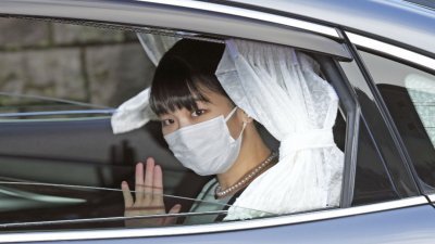 日本真子公主离开东京赤阪庄园时，在车内向媒体挥手致意。（图取自路透社/共同社）