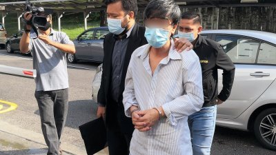 被告郑春秀（右，译音）周三上午在反贪会官员押送下，在新山反贪会法庭面对23项控状。