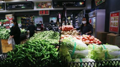 中国青海省海东市平安区一家超市内，顾客正挑选蔬菜。（图取自中新社）