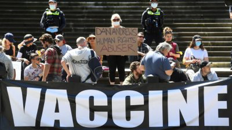 反疫苗接种和反封锁抗议者周二坐在墨尔本维多利亚州议会的台阶上，因为州政府宣布了新法律以取代有争议的紧急状态权力。（图取自法新社）