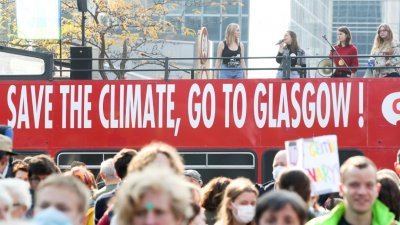 在比利时首都布鲁塞尔，人们于本月10日在苏格兰格拉斯哥联合国气候变化大会登场前，举行气候游行。（图取自路透社）