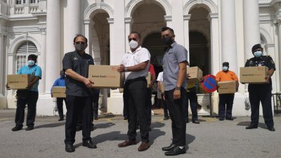 佳日星（中）象征式移交食物篮给予槟岛市政厅秘书拿督安南（右），并将派发给予受惠的槟岛市政厅人员。