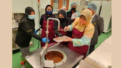 祖莱达（右）巡视汝来马来西亚可可局技术及研究中心时，亲自体验制作巧克力过程。