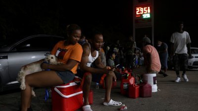 风暴造成新奥尔良市部分地区停电，市民尤金尼娅和布儒瓦在加油站等了5个小时，希望能够买燃油启动发动机，解决燃眉之急。（图取自路透社）

