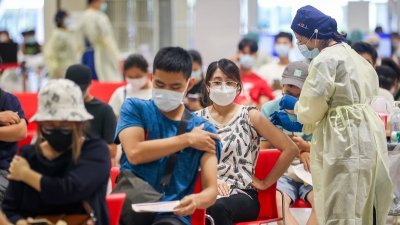 台湾中小学周三正式开学，恢复实体上课。学校教职员等相关工作人员赶在前一天到接种站施打疫苗。（图取自中央社）