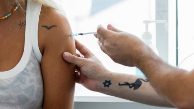 在以色列特拉维夫，一名女子周一接种第3剂新冠肺炎疫苗。（图取自路透社）