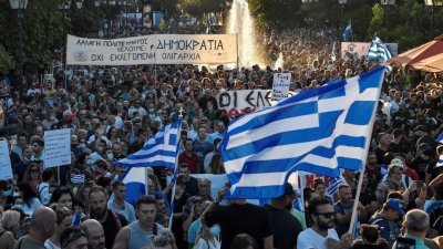 大批民众上周日聚集在雅典的宪法广场，他们挥舞著希腊国旗、举著“反对法西斯主义”、“民主万岁”等标语横幅和牌子，抗议政府新的防疫措施。（图取自法新社）