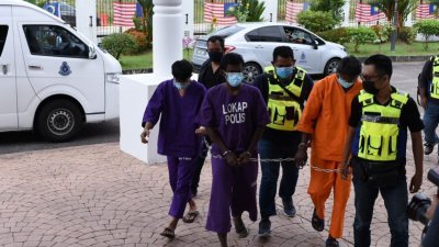 警方将涉及奸杀威南独居女书记一案的嫌犯（中），押往大山脚法庭申请延扣令。