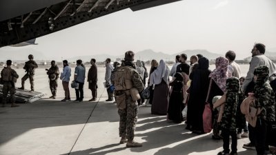 美国从阿富汗撤出数以万计的难民，其中许多是老夫少妻。（图取自路透社）