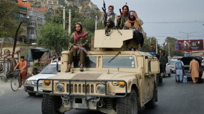 塔利班连日庆祝美军完全撤出阿富汗，本周二在首都喀布尔，有塔利班战士坐上美制悍马车进行巡游。（图取自法新社）